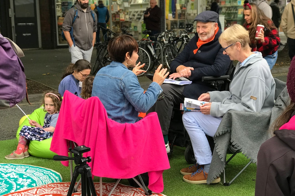 A group of people sitting on comfortable chairs, smiling and chatting