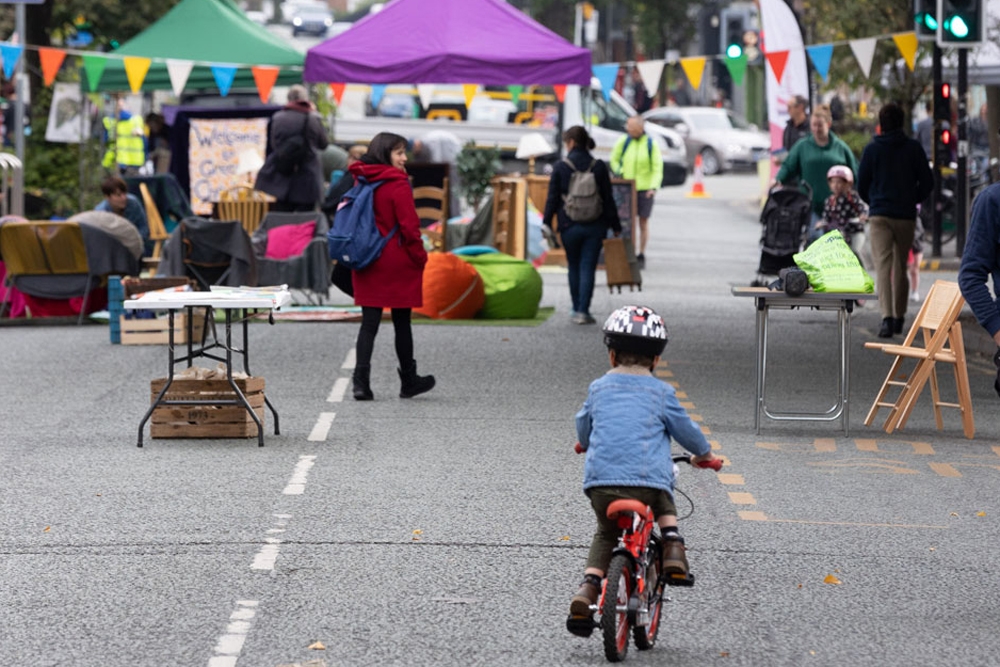 a small boy rides his bike up and down a car-free main road