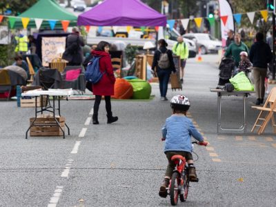 a small boy rides his bike up and down a car-free main road